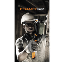 Meșter cu cască și ochelari de protecție ținând un ciocan Fiskars Pro în timp ce bate un cui