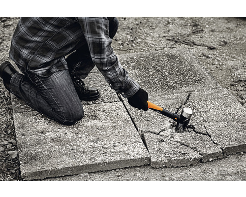 O persoană care lucrează cu un ciocan pe pavaje.