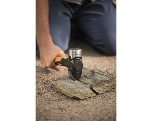 Bărbat despărțind o piatră cu un ciocan de forță