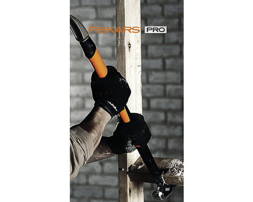 O persoană folosește un ciocan Fiskars Pro pentru a bate un cui într-o bucată de lemn.