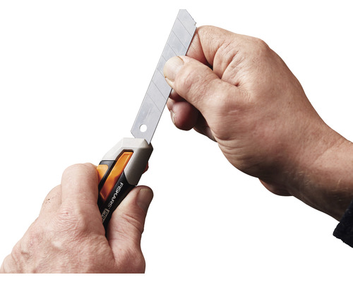 Persoană care ține un cuțit cu lamă retractabilă cu o lamă