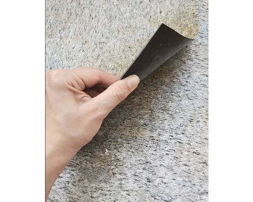 Mână ținând o mostră de acoperire a podelei