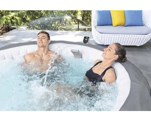 Cadă cu hidromasaj gonflabilă cu doi oameni relaxați în grădină.