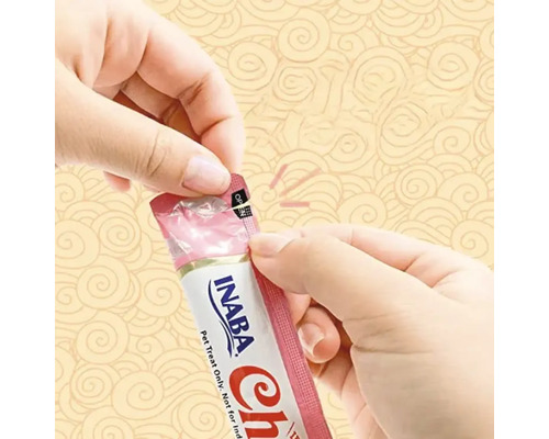 O persoană deschide un pachet de recompense pentru pisici Inaba Churu.