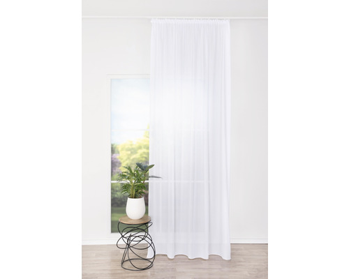 Perdea în fața ferestrei cu plantă pe măsuța laterală