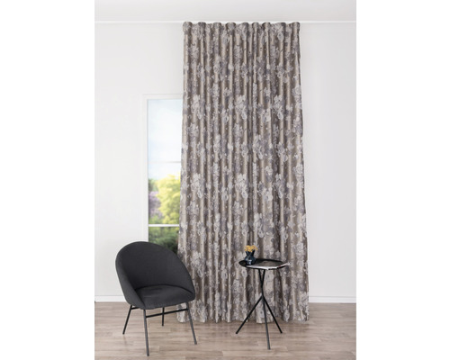 Cortină decorativă cu model floral lângă un scaun și o măsuță laterală