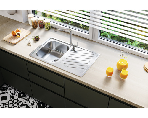 Chiuvetă din oțel inoxidabil cu uscător și baterie monocomandă într-o bucătărie modernă.