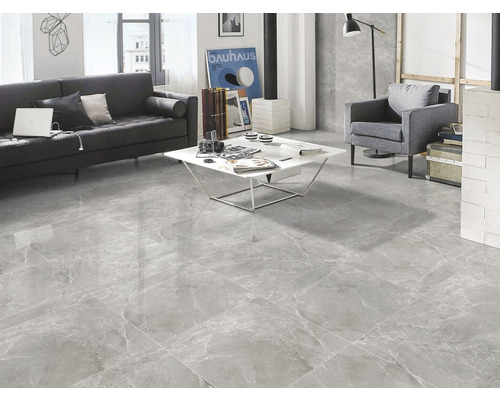 Living luminos cu podea de marmură gri, canapea, fotoliu și măsuță de cafea