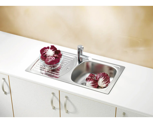 Chiuvetă din oțel inoxidabil cu picurător și baterie pe un blat de bucătărie