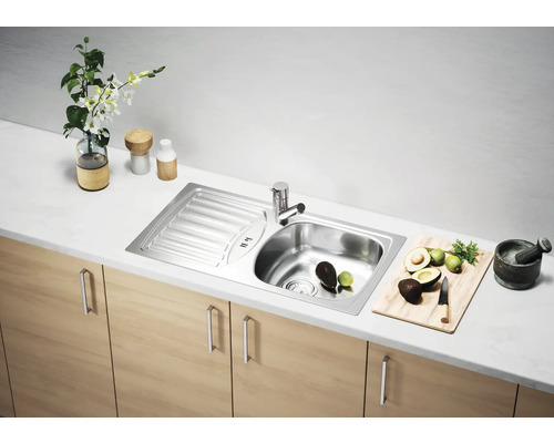 Chiuvetă din oțel inoxidabil cu uscător într-o bucătărie luminoasă