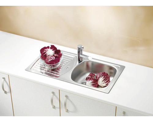 Chiuvetă de bucătărie din oțel inoxidabil cu picurător și robinet pe un dulap de bucătărie