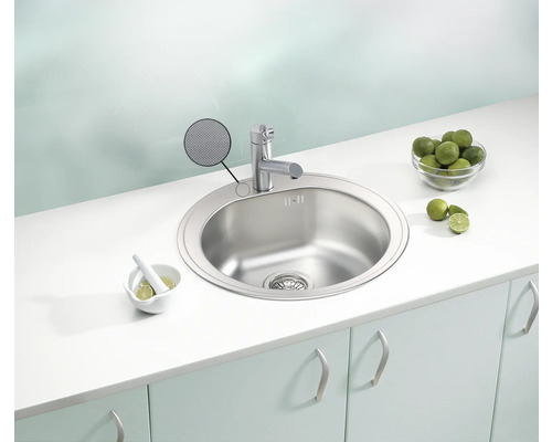 Chiuvetă din oțel inoxidabil cu robinet într-un cadru de bucătărie luminos.