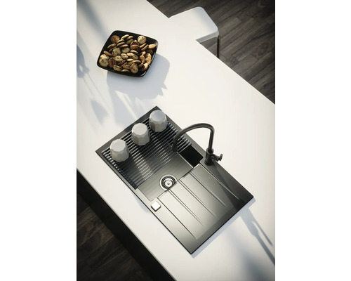 Chiuvetă de bucătărie cu uscător, robinet, cești și un bol cu produse de patiserie pe un blat de bucătărie.