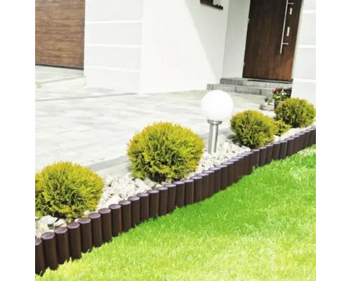 Scenă de grădină cu bordură Rollboarder, plante și gazon în fața unei case de locuit