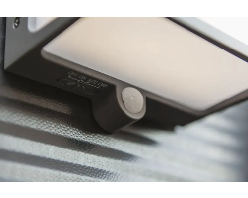 Prim-plan cu o lumină de exterior cu senzor de mișcare și comutator pentru oprit, pornit, automat și estompare.