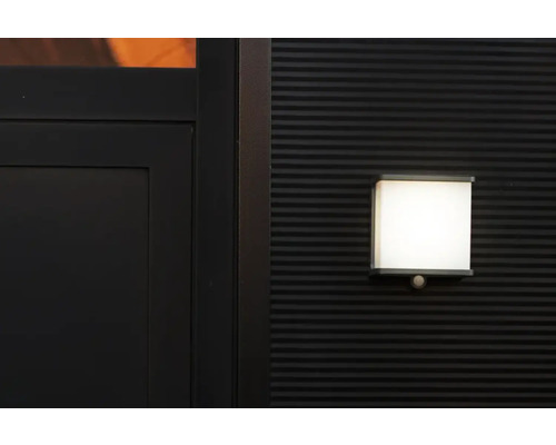 Lumină de exterior pătrată cu senzor de mișcare pe un perete texturat