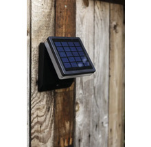 Lampă solară montată pe un perete de lemn
