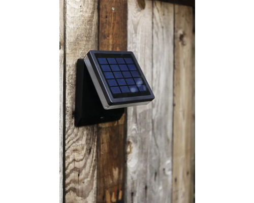 Lampă solară montată pe un perete de lemn