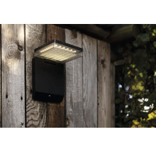 Lumină de exterior cu senzor de mișcare pe perete de lemn