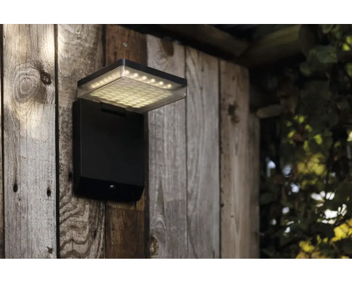 Lumină de exterior cu senzor de mișcare pe perete de lemn