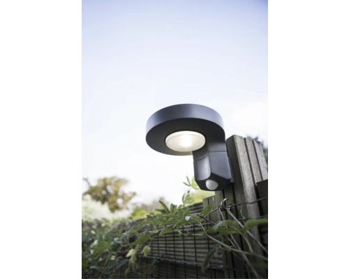 Lumină de exterior cu senzor de mișcare pe un gard din lemn