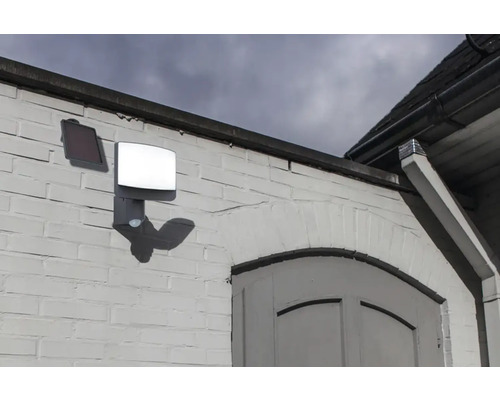 Lampă solară cu senzor de mișcare pe un perete de casă