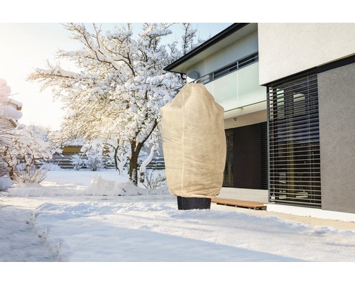 Peisaj de iarnă cu sac de protecție pentru plante în grădină