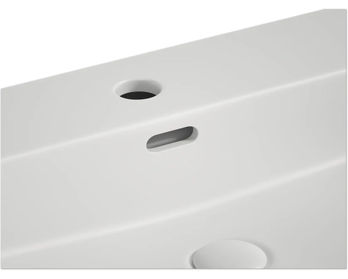 Imagine detaliată a unei chiuvete albe cu scurgere și orificiu pentru robinet