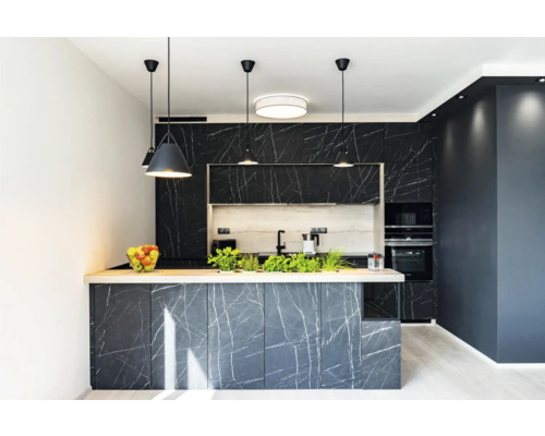 Bucătărie modernă cu insulă de bucătărie, fronturi din marmură neagră și corpuri de iluminat suspendate.