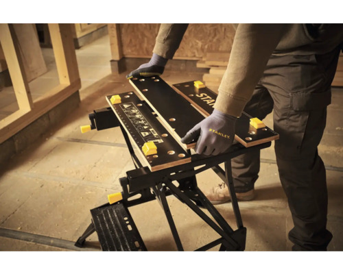 Banc de lucru Stanley cu o persoană care ține o bucată de lemn.