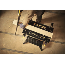 Logo Stanley. Bărbat taie lemn pe un banc de lucru.