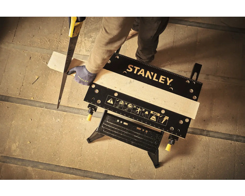 Logo Stanley. Bărbat taie lemn pe un banc de lucru.