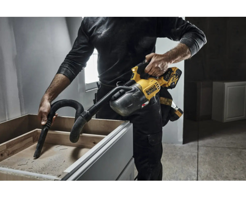 Un bărbat folosește un aspirator portabil DeWalt pentru a aspira un dulap.