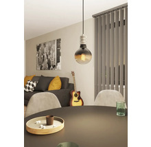 Lampa suspendată decorativă cu bec deasupra unei mese de sufragerie într-un living.