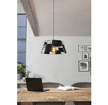 Lumină suspendată neagră din metal cu design decorativ deasupra unei mese din lemn