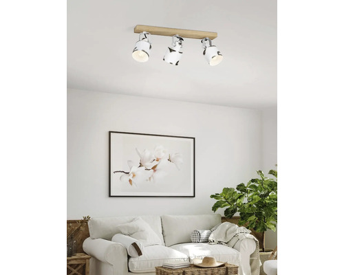 Lumină de plafon cu trei spoturi și bază de lemn într-o sufragerie.