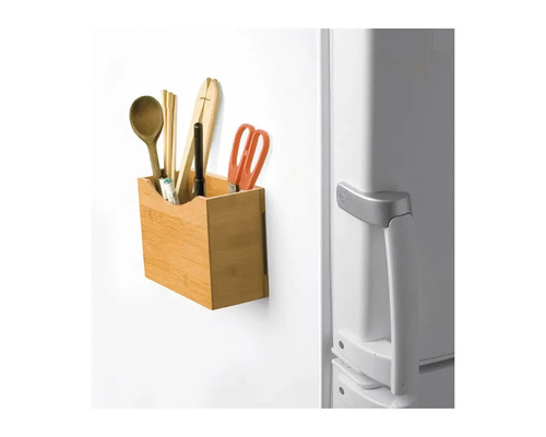 Recipient din bambus cu ustensile de bucătărie pe un frigider