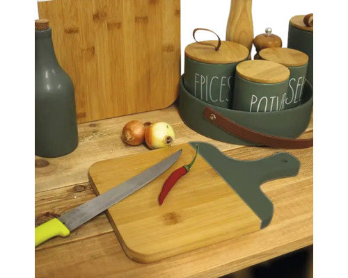 Scenă de bucătărie cu tocătoare, cuțite, condimente și ceapă pe o masă de lemn.