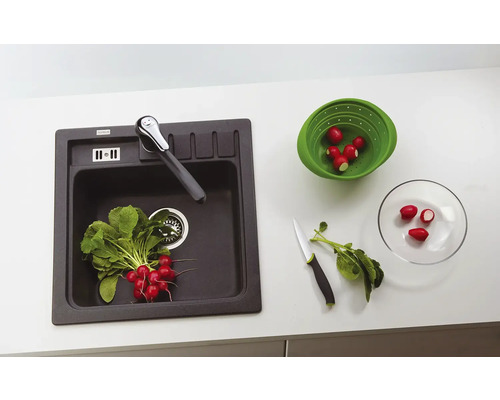 Chiuvetă de bucătărie cu robinet, ridichi într-o sită și pe o farfurie