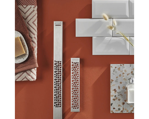 Scenă de baie cu două radiatoare metalice cu model perforat, prosoape, săpun, faianță și loțiune.