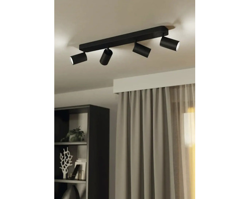 Lumină de tavan neagră cu patru spoturi în camera de zi