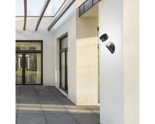 Lumină modernă de perete pentru exterior din metal și sticlă pe un perete de casă