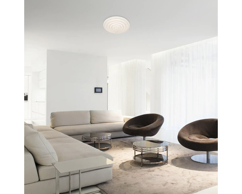 Cameră de zi cu canapele, fotolii, mese și o plafonieră rotundă