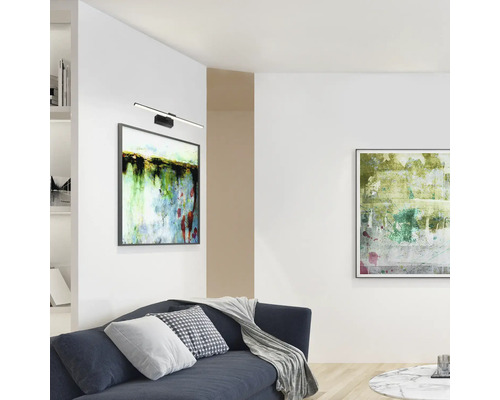 Cameră de zi cu canapea, măsuță de cafea, lămpi de perete și tablouri înrămate