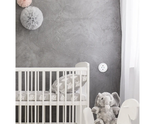 Cameră de copii cu pătuț, pernă, elefant de pluș și decorațiuni