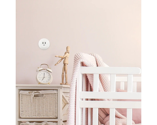 Priză electrică în camera copilului cu pătuț și decorațiuni