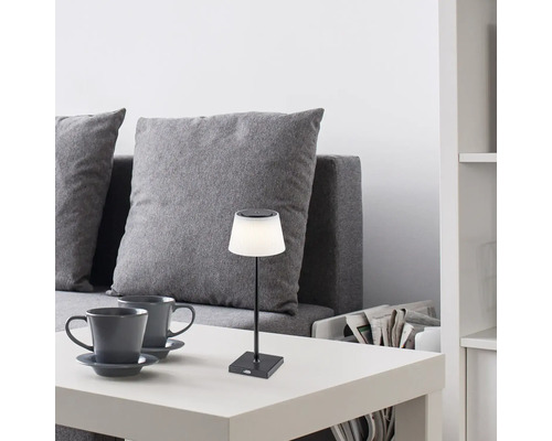 Scenă cu o lampă de masă pe o masă lângă o canapea