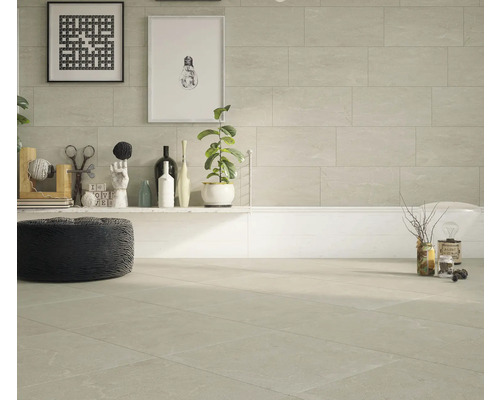 Baie luminoasă cu gresie pe podea și perete, cadă și decorațiuni