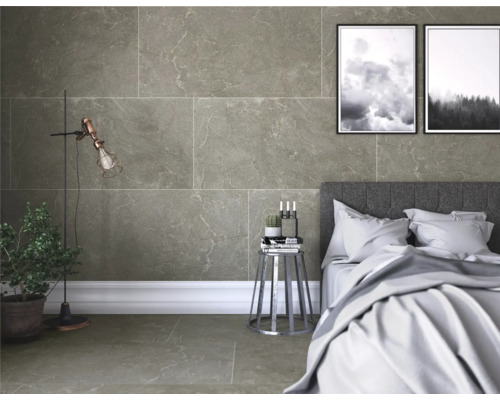 Dormitor cu gresie și faianță cu aspect de piatră, pat și decorațiuni.