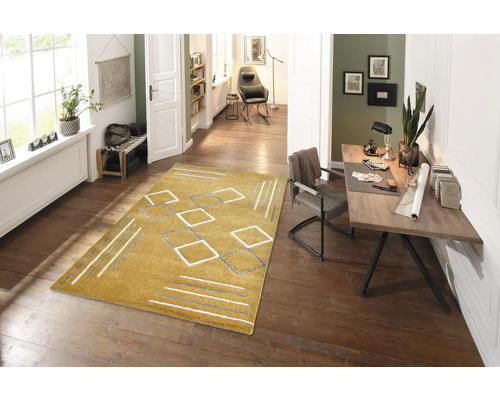 Cameră de zi cu covor galben cu modele geometrice pe podea de lemn